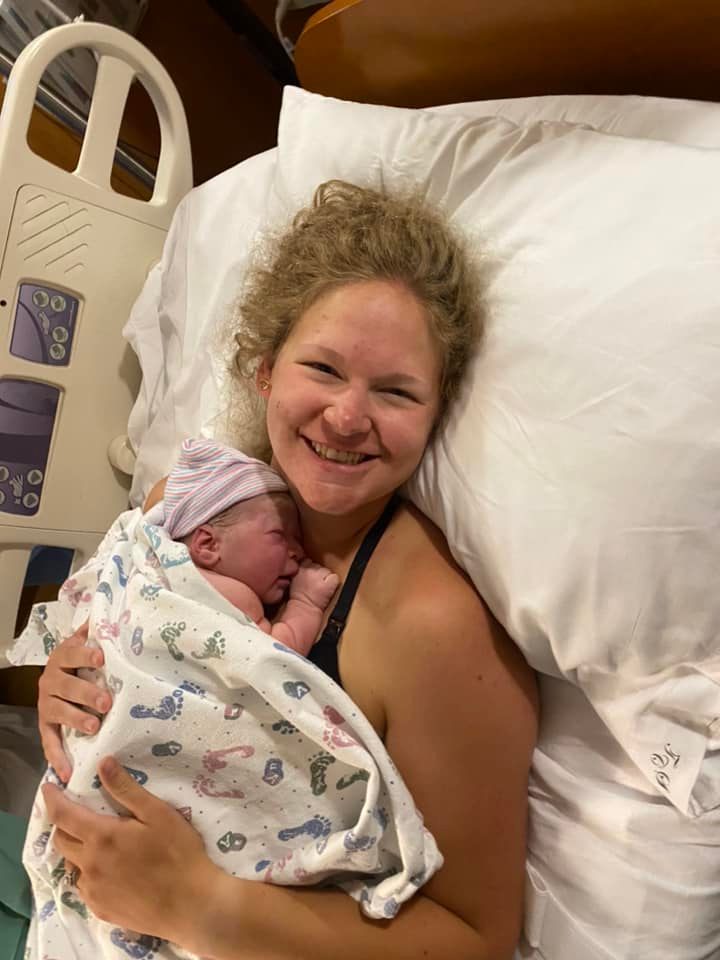 woman holding new born baby in hospital